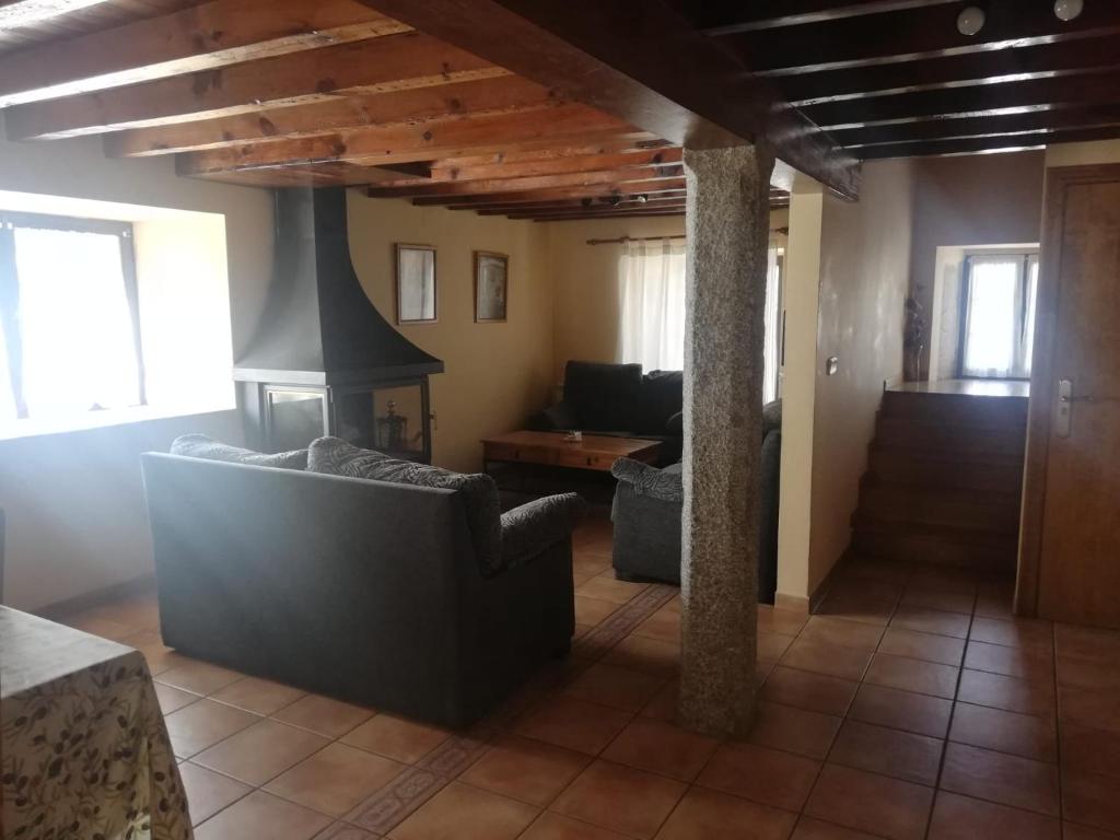 a living room with a couch and a stove at Casa Rural del Chopo in La Aliseda de Tormes
