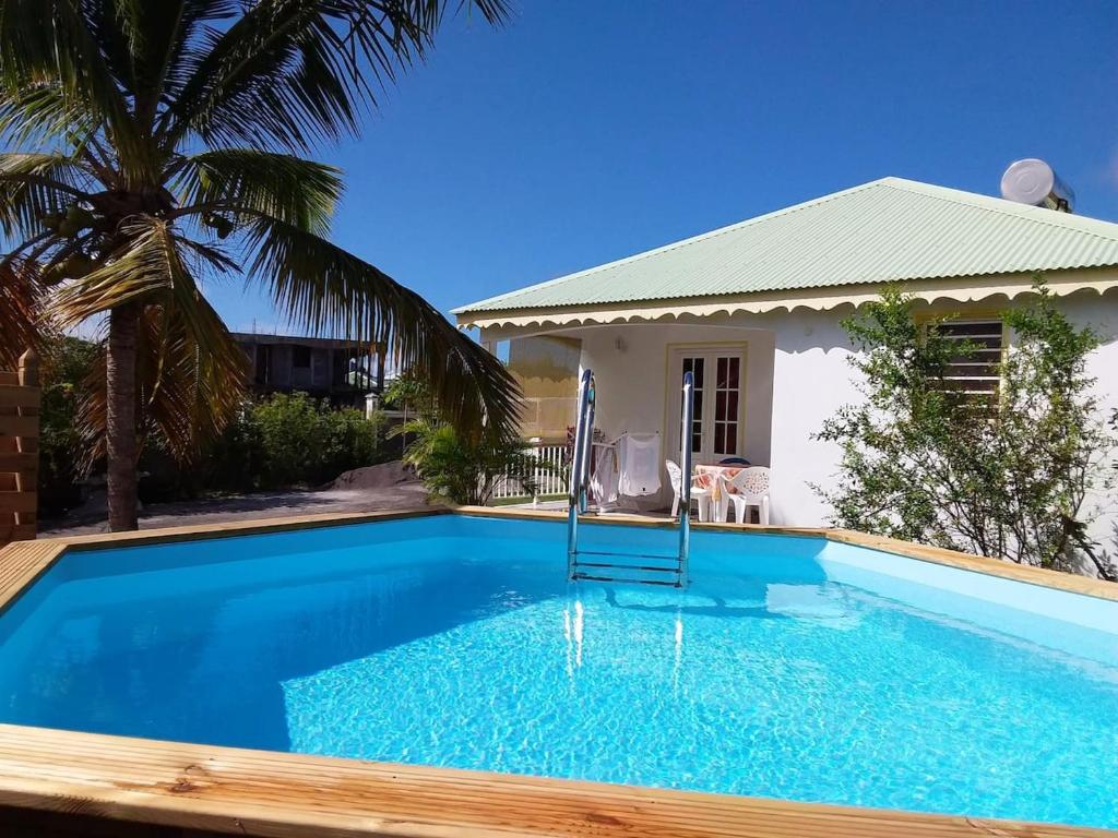 ein Pool vor einem Haus in der Unterkunft Maison de 2 chambres avec piscine partagee jardin amenage et wifi a Le Moule in Le Moule