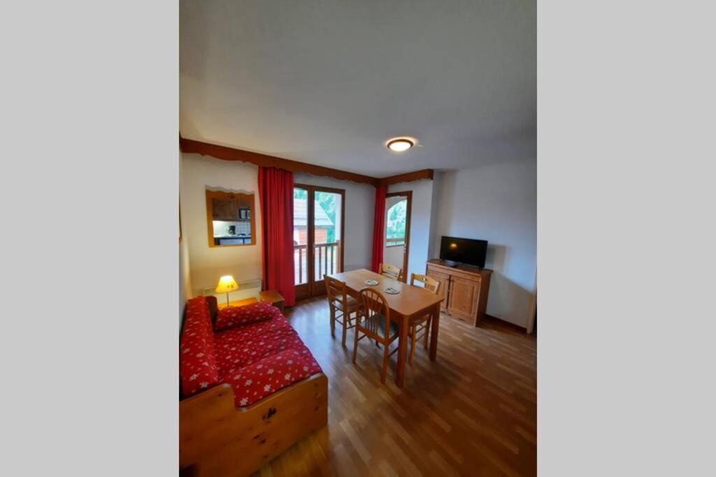 a living room with a table and a couch at Appartement en plein coeur du Queyras - Les Granges d'Arvieux in Arvieux