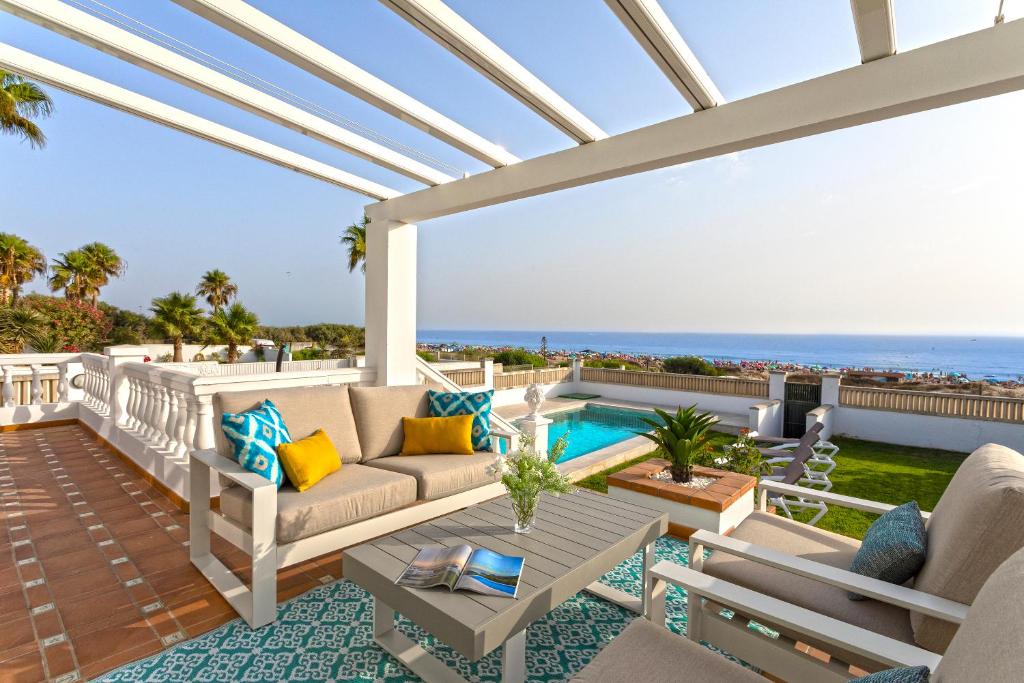 a patio with a view of the ocean at Genteel Home Mirador de La Barrosa in Chiclana de la Frontera