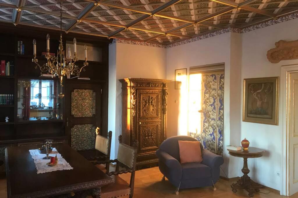 een woonkamer met een tafel en een stoel bij In einer Wohnung durch die Jahrhunderte in Feistritz an der Drau