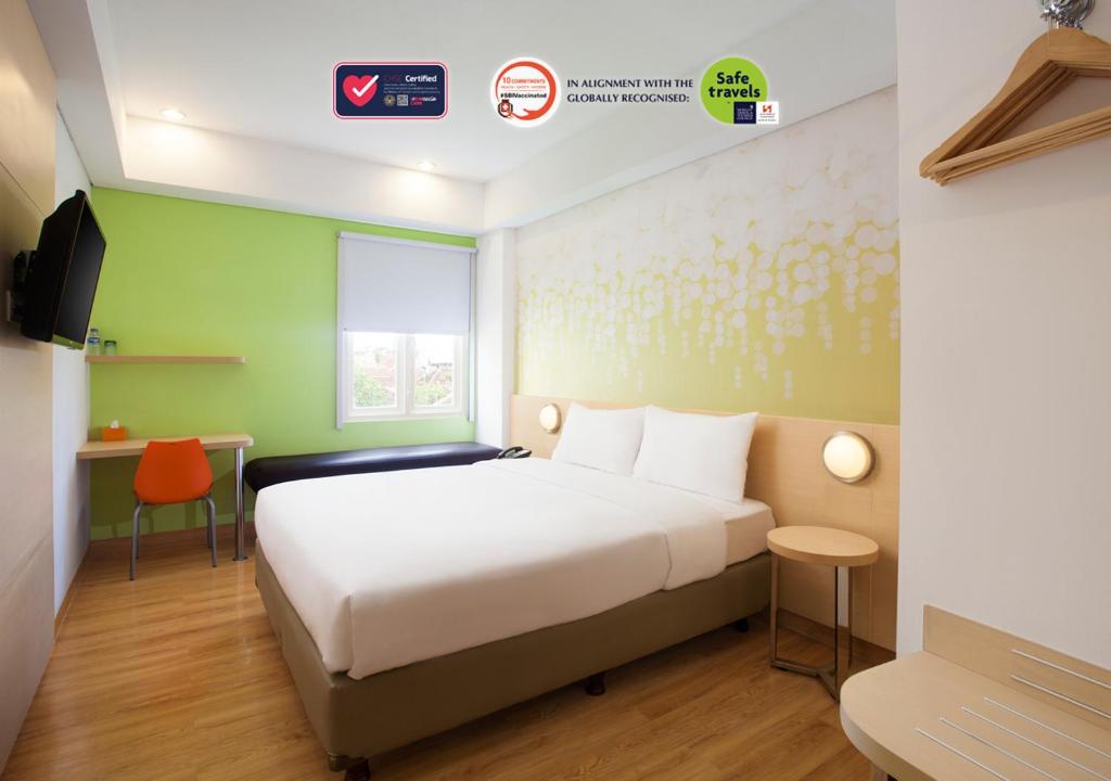 Un pat sau paturi într-o cameră la Zest Yogyakarta by Swiss-Belhotel International