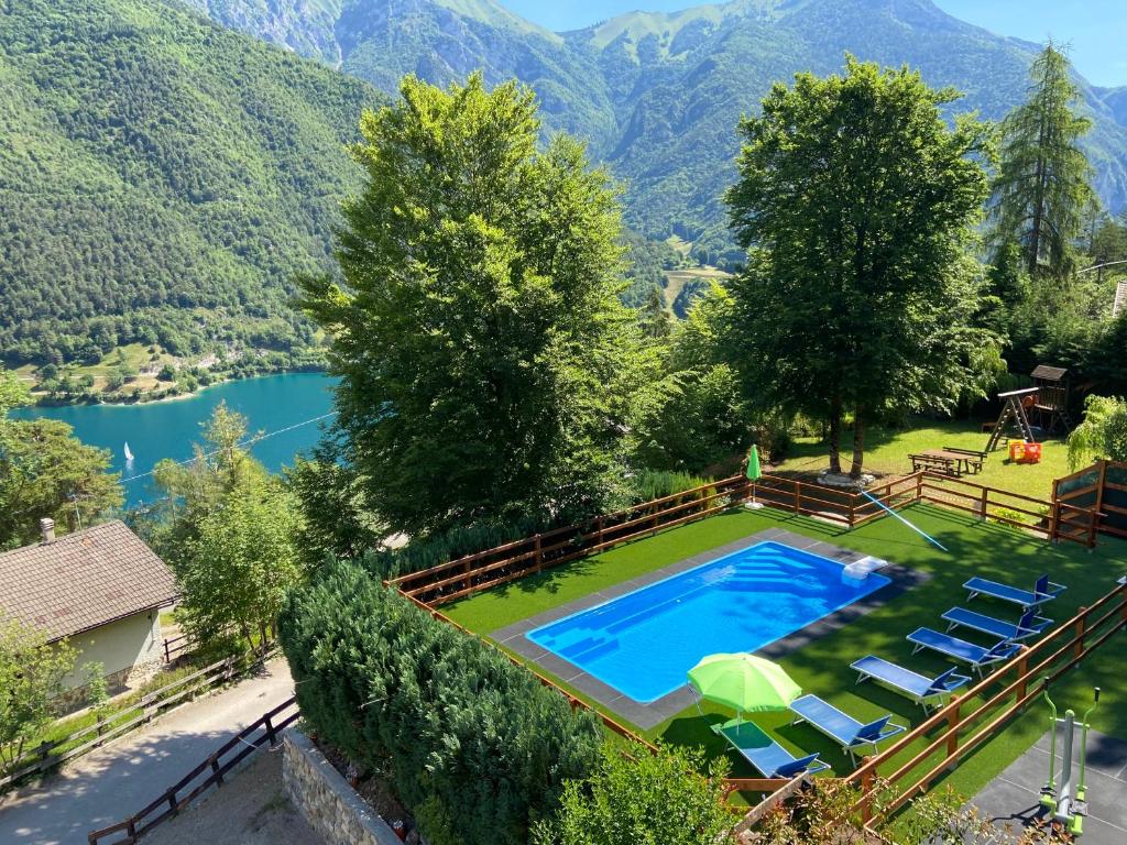 an overhead view of a swimming pool with chairs and a lake at Le Terrazze - Ledro House in Pieve Di Ledro