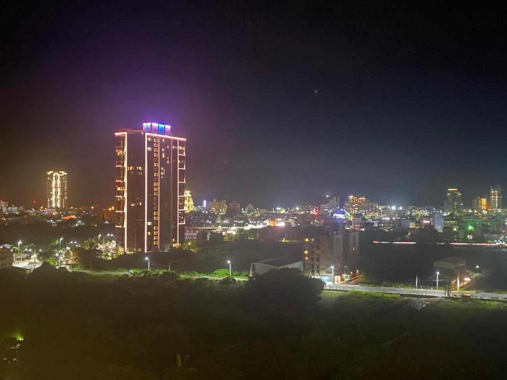 una ciudad iluminada por la noche con edificios en 晨曦溫泉宅 en Toucheng