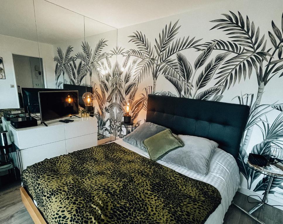 Beautiful modern fully furnished studio في لوفالوا بيريه: غرفة نوم بسرير وجدار بالنباتات