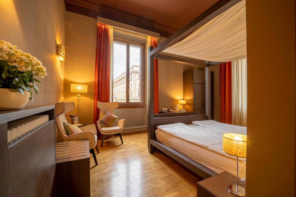 - une chambre avec un lit à baldaquin et une fenêtre dans l'établissement B&B Repubblica, à Florence