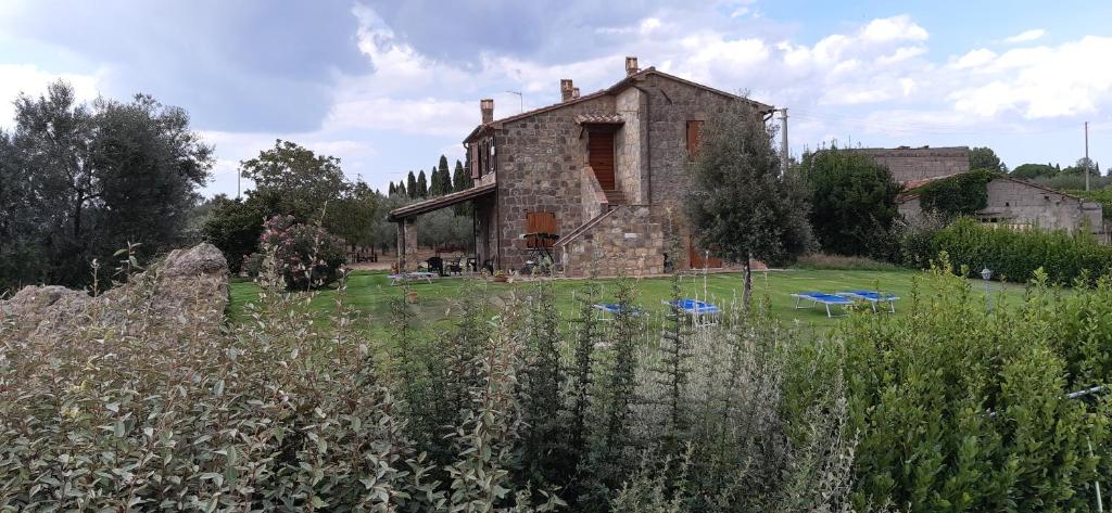 uma velha casa de pedra no meio de um campo em Agriturismo Le Sorgenti em Pitigliano