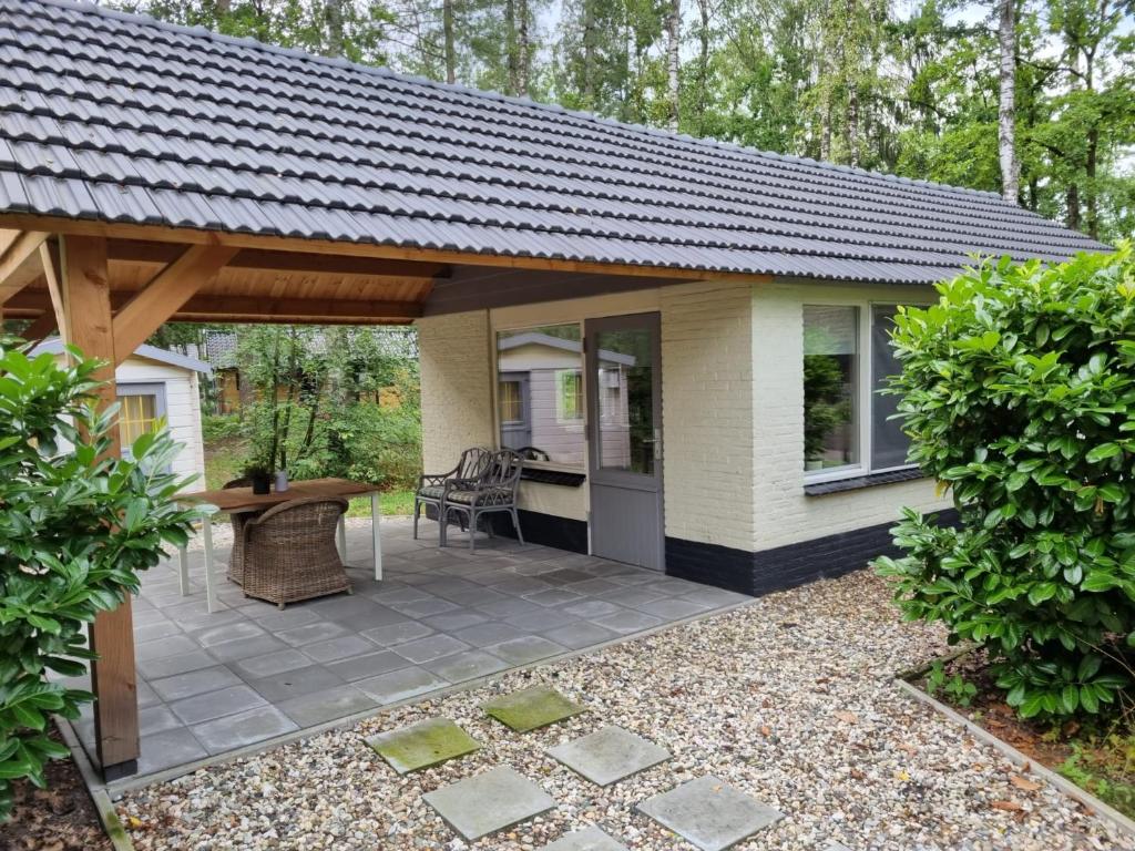 a house with a patio with a roof at 't Vosseven vakantiehuizen in Stramproy