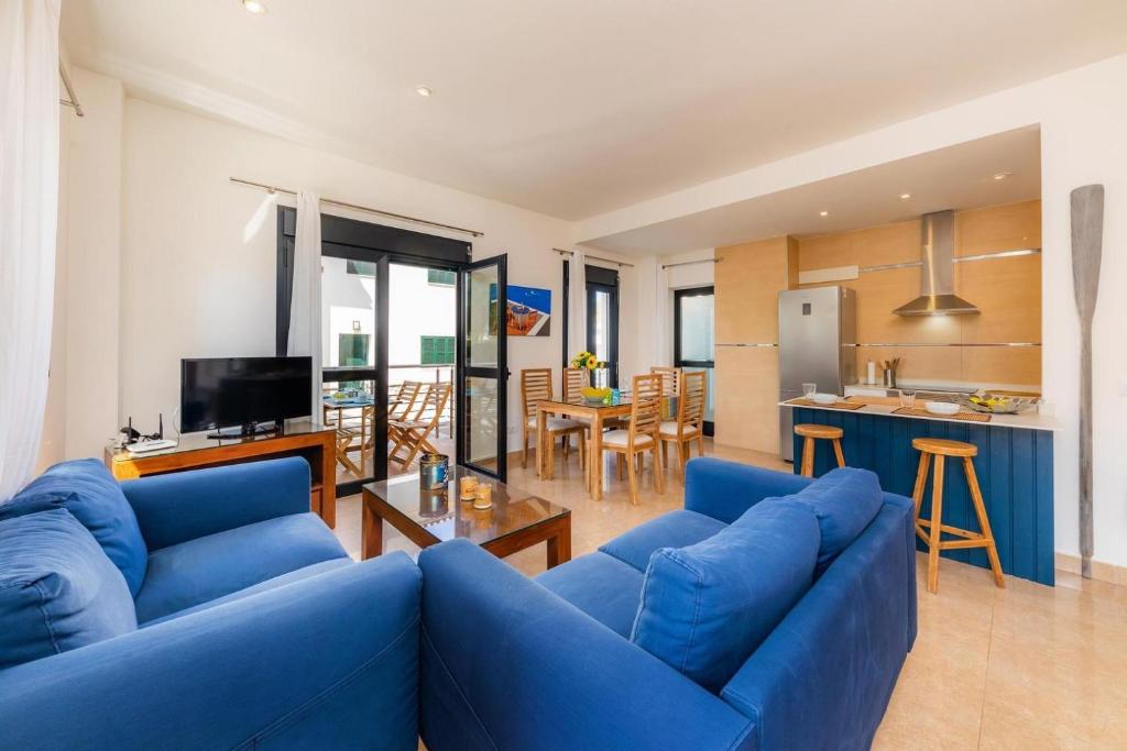 波延薩的住宿－Can Joan，一间带蓝色沙发的客厅和一间厨房