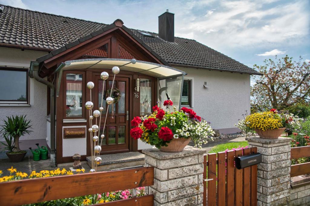 a house with flowers in front of a fence at Ferienwohnung Werner mit Terrasse in Haundorf