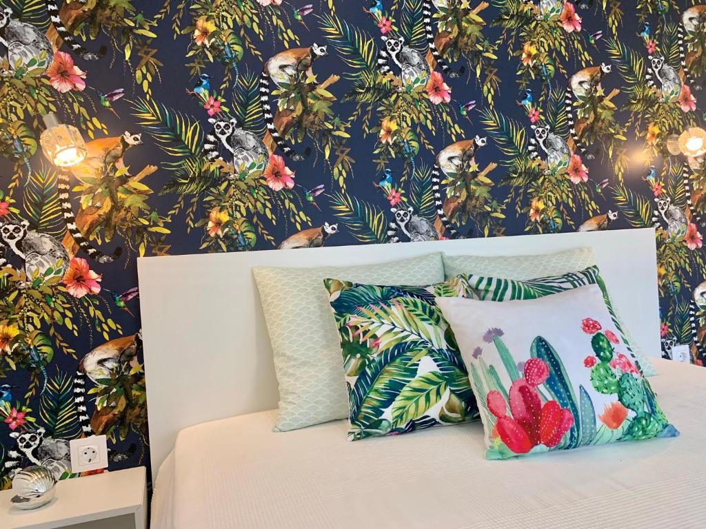 a bedroom with a bed with a tropical wallpaper at Madagascar Apartman Keszthely in Keszthely