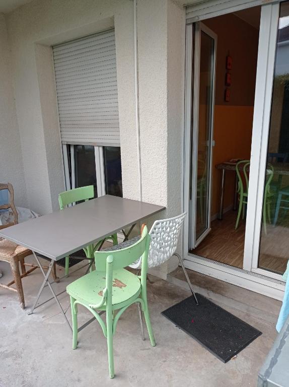 una mesa y sillas en un porche con mesa y sillas en Chambre chez l'habitant en Saint Die