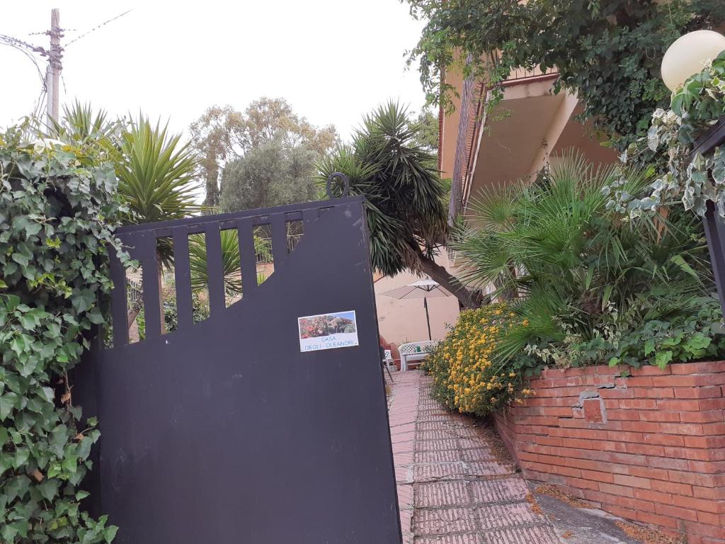 een zwarte deur met een sticker erop in een tuin bij CASA DEGLI OLEANDRI in Carlentini
