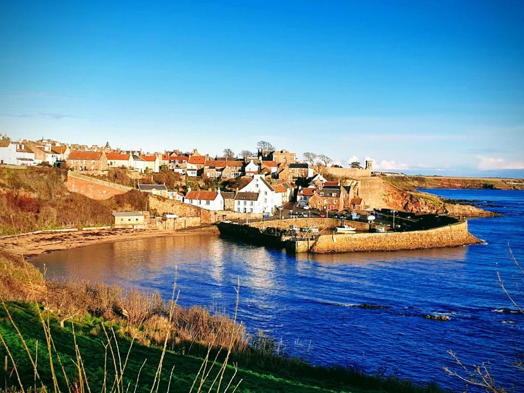 a small town next to a body of water at Harbour Lights - Spectacular Sea Views in Crail