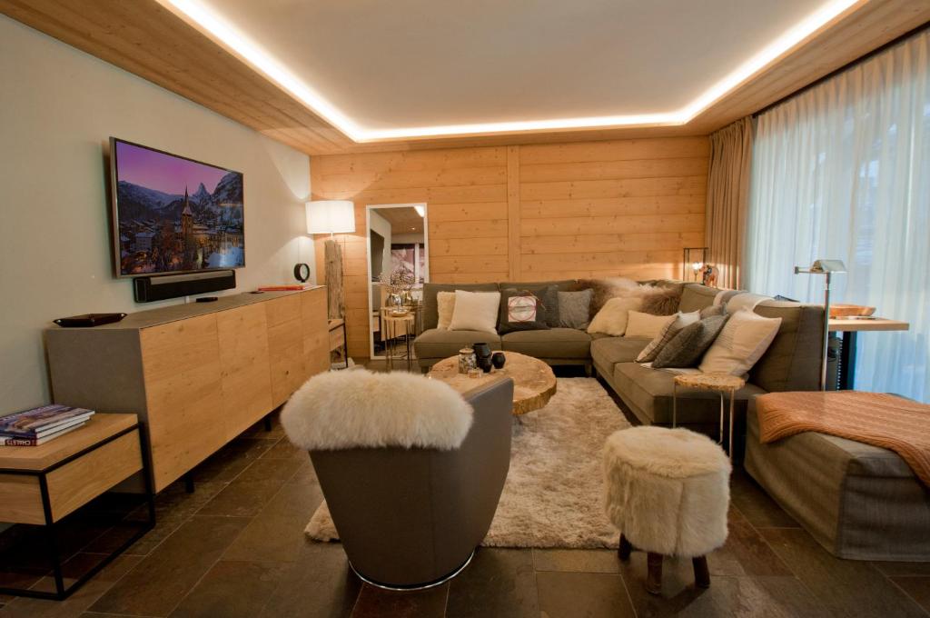 een woonkamer met een bank en een tv bij Twin Peak apartment at Nevada prime in Zermatt