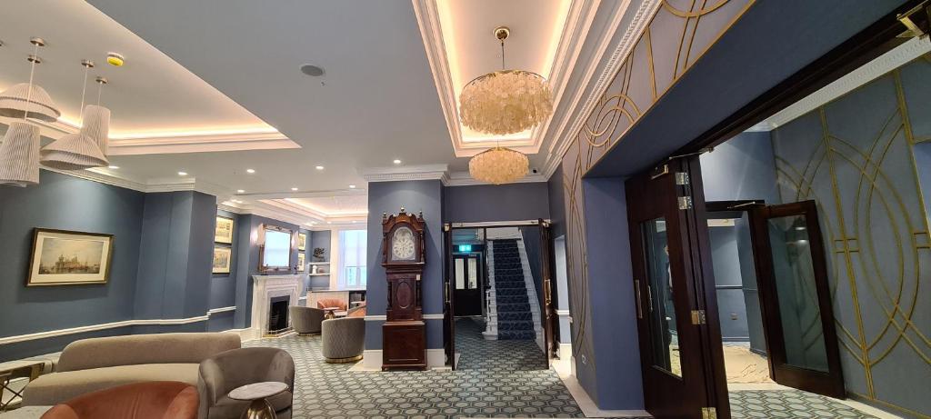 a lobby with blue walls and a clock on the wall at Commodore Hotel in London