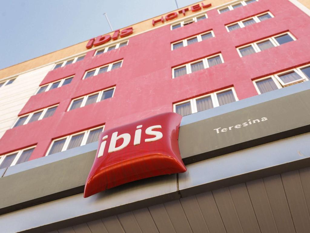 um sinal ibis vermelho na lateral de um edifício em Ibis Teresina em Teresina
