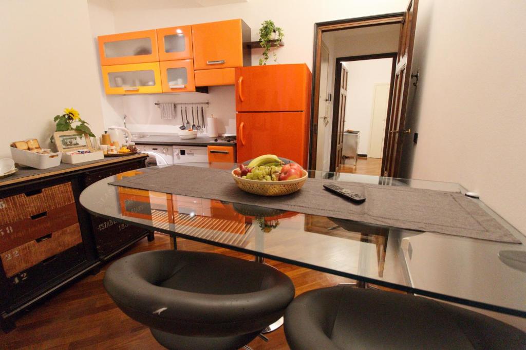 a kitchen with a glass table with a bowl of fruit at Casa ETERIA in Genova