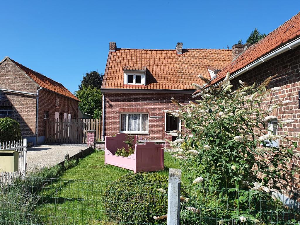 a brick house with a garden in the yard at Haspengouws Hoeveke in Borgloon