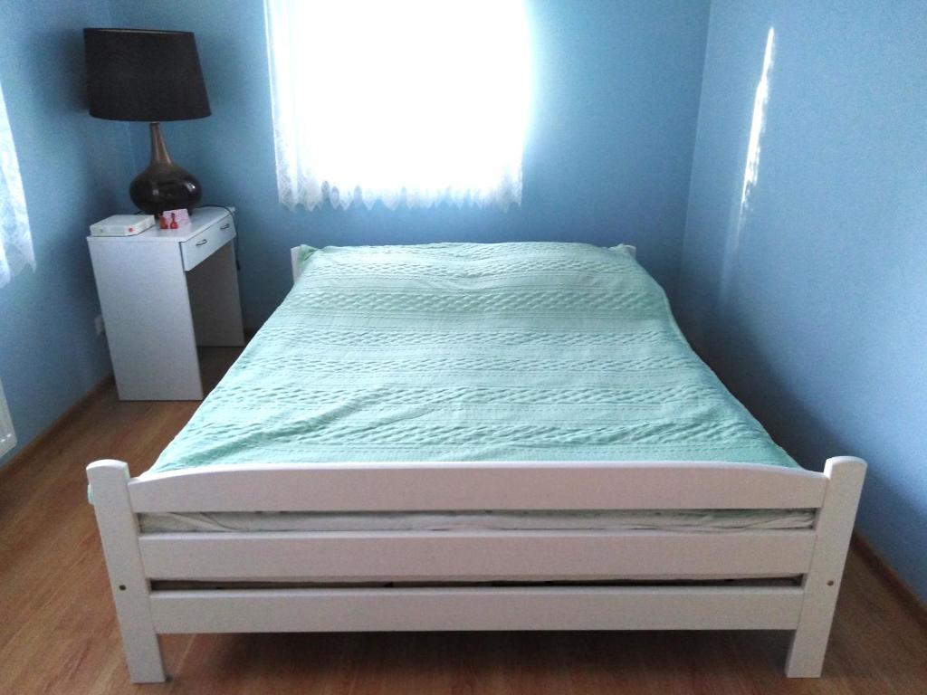 łóżko w sypialni z niebieską ścianą w obiekcie Zaciszny Zakątek w mieście Drohiczyn