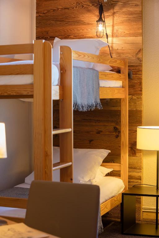 a room with bunk beds with a desk and a laptop at Hillary Hotel in Les Menuires