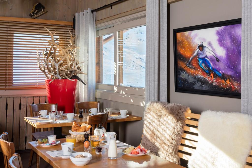 a dining room with a table and a window at Hillary Hotel in Les Menuires