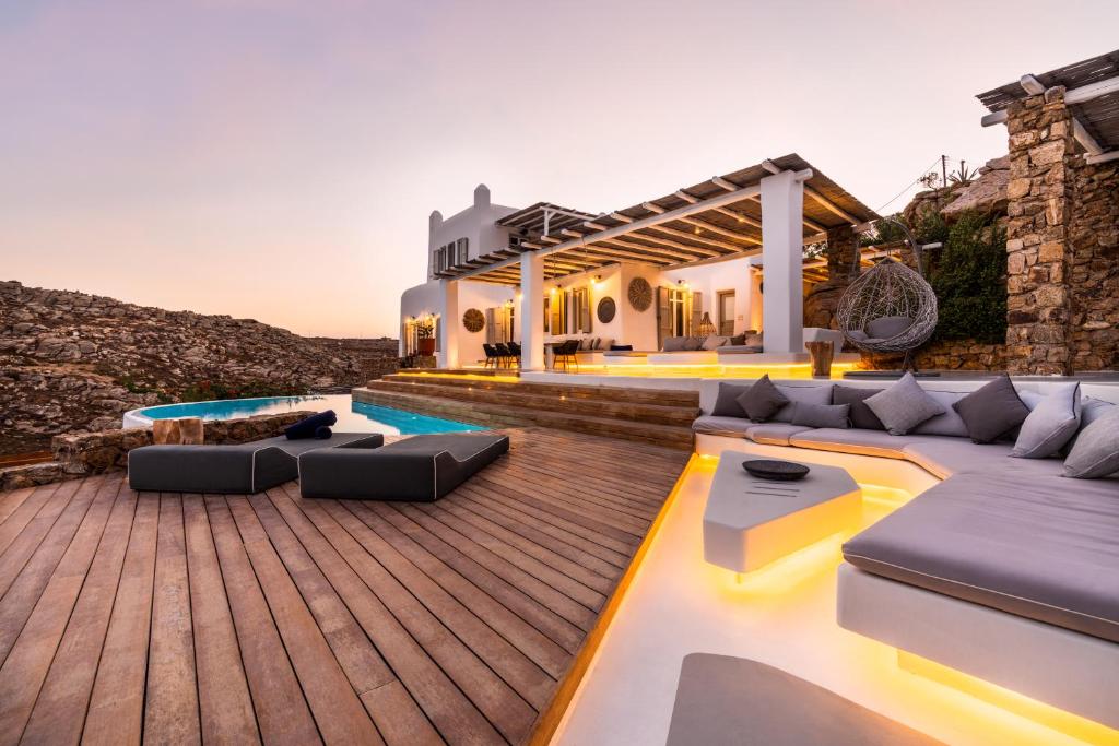 a backyard of a house with a wooden deck at Villa Artisti Mykonos in Agrari