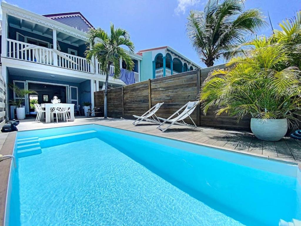 a swimming pool in front of a house at Villa Casalilo, Orient Bay in Orient Bay