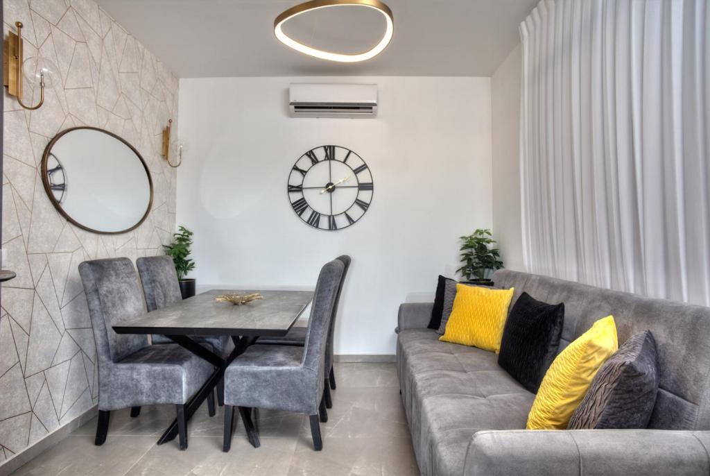a living room with a couch and a table and a clock at אחוזה בהרים in Meron