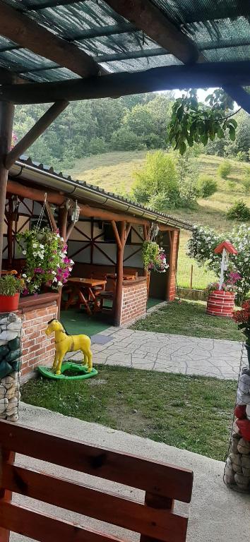 a small yellow horse statue in front of a house at Apartman Denis Una in Lužine