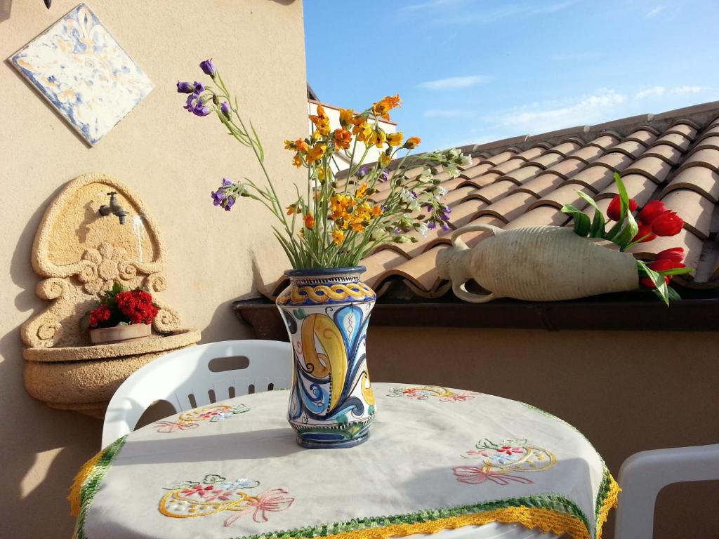un jarrón con flores sentado en una mesa en Casevacanze Sanvito, en Sciacca