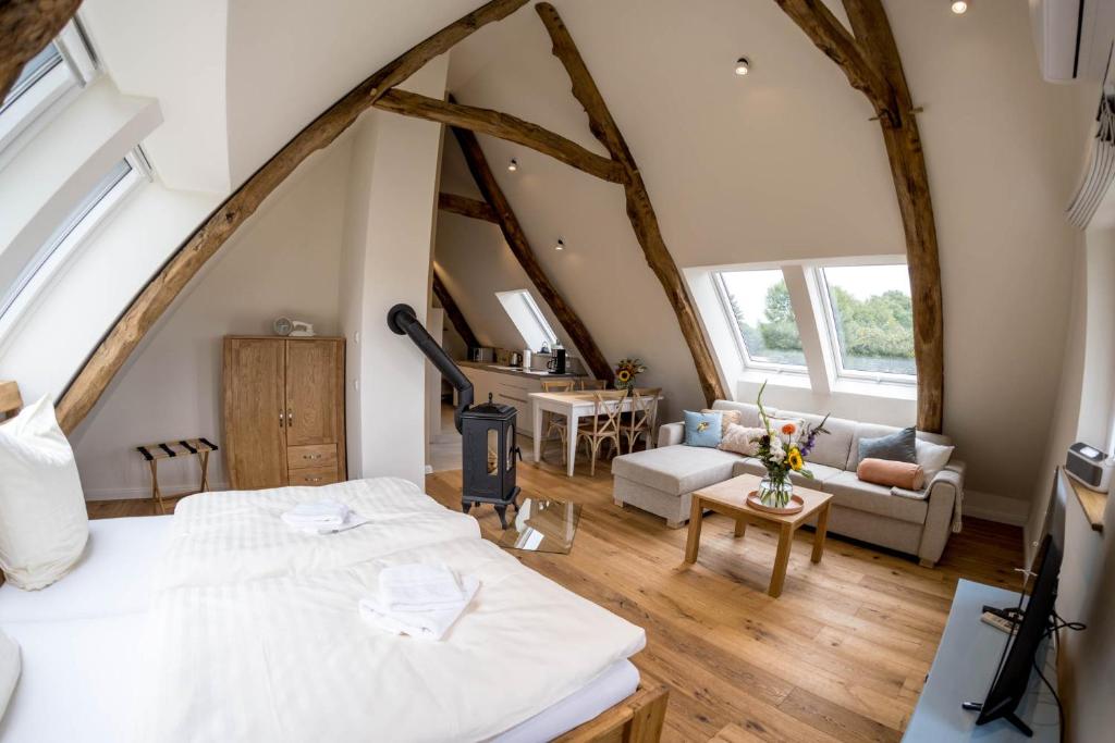 VersmoldにあるZum Heuerling Ferienwohung Leinenstube mit Saunaの屋根裏のベッドルーム(ベッド1台付)、リビングルームが備わります。