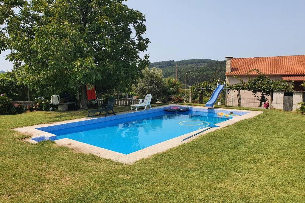 a swimming pool with a slide in a yard at Apartamento A Fontiña in Pontevedra