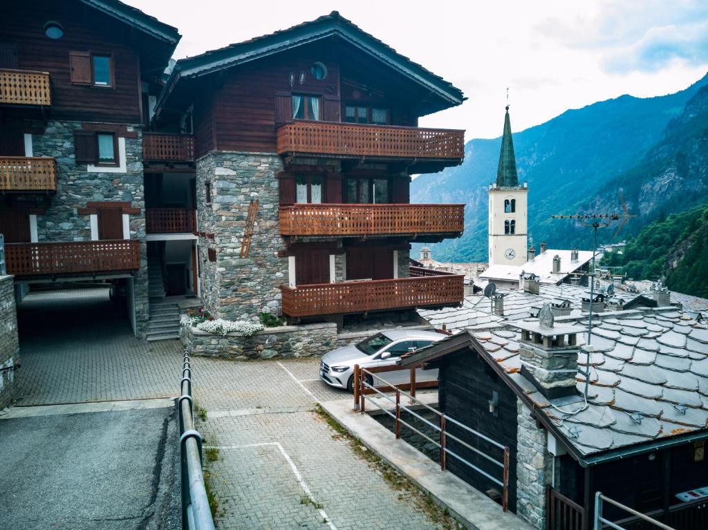 un edificio con un coche estacionado junto a una iglesia en "Lo méquio de Emilie" 2 passi da centro e piste en Valtournenche