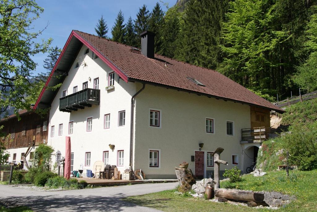 a large white house with a brown roof at Ferienwohnung Bluntaumühle in Golling an der Salzach