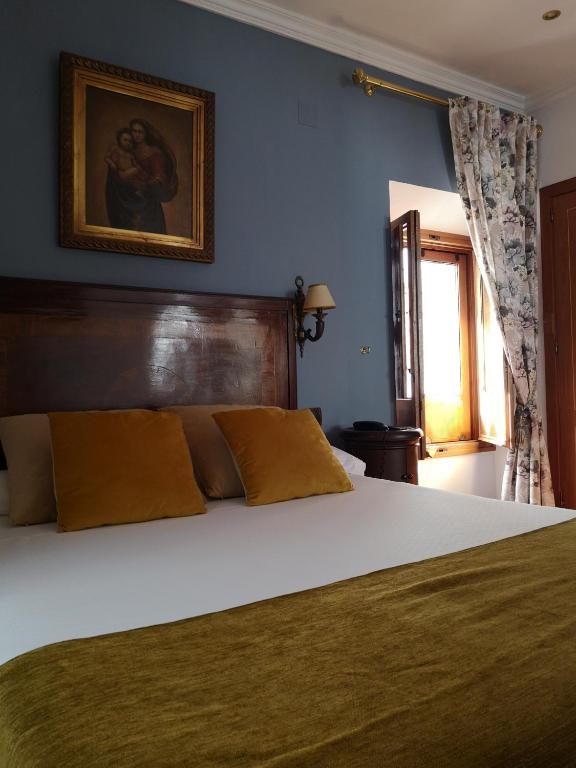 A bed or beds in a room at La Llave de la Judería Hotel Boutique
