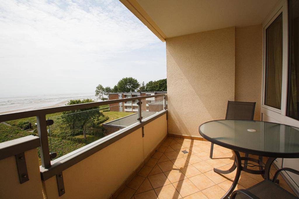 a balcony with a table and a view of the ocean at Haus Uthlande Uthlande Whg 23 Lütte Bris in Wyk auf Föhr
