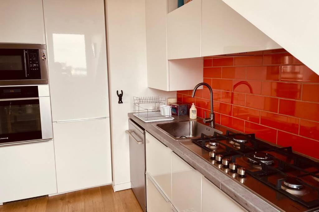 a kitchen with a sink and a stove top oven at **La Bretonnerie, bel appartement de standing in Concarneau