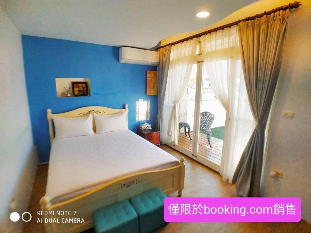 Un dormitorio con una cama y una ventana grande. en 玖拾捌民宿-98bnb, en Hualien City