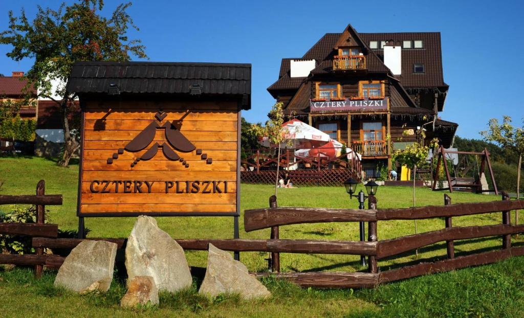 a sign in a field next to a fence at Cztery Pliszki in Gródek Nad Dunajcem