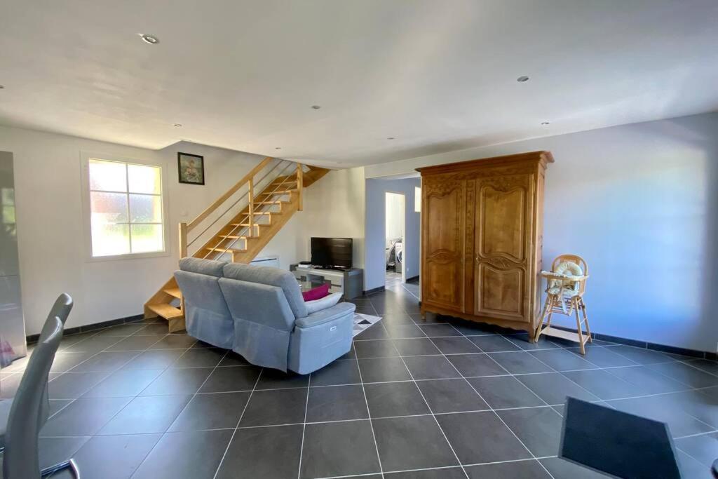 un salon avec un canapé et un escalier dans l'établissement La Grange, à Moyenneville