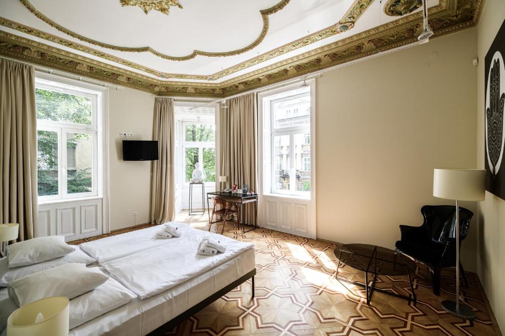 a bedroom with a bed with a coffered ceiling and windows at Home Aparthotel in Krakow