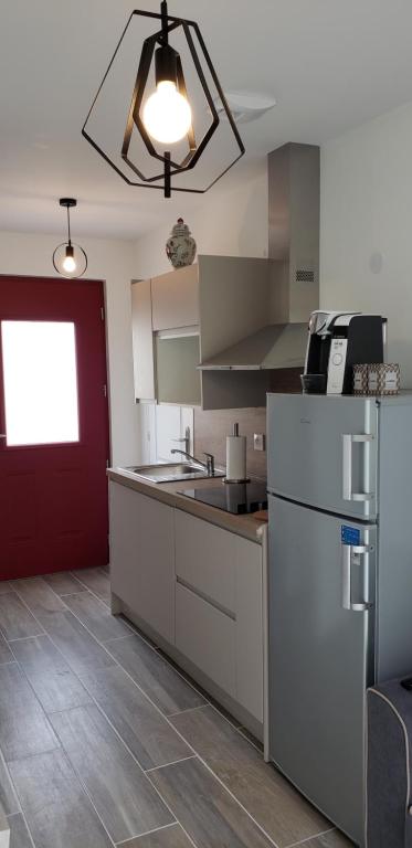 uma cozinha com um frigorífico branco e uma porta vermelha em Dives sur Mer em Dives-sur-Mer