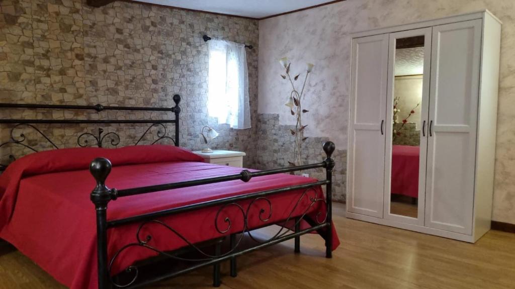 - une chambre avec un lit doté d'une couverture rouge et d'une porte dans l'établissement Trinacria, à Catane