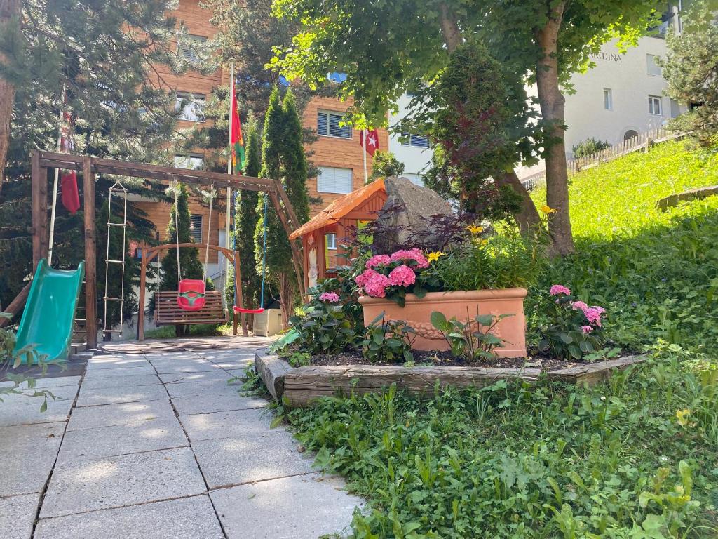 a garden with flowers and a swing at Alpenblick in Zermatt