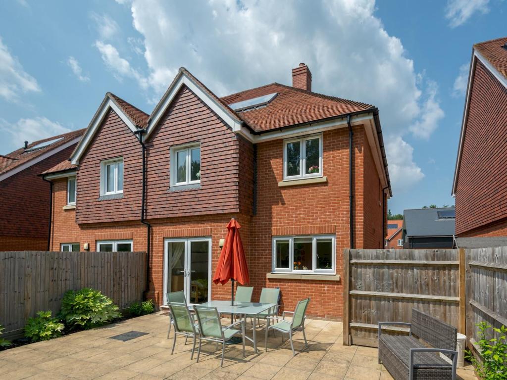 a brick house with a patio with a table and chairs at Pass the Keys Cheerful 2-Bedroom house with Private parking in Canterbury