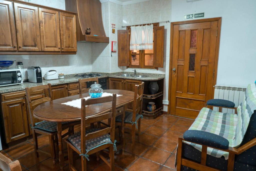 una cucina con tavolo e sedie in legno e un tavolo di Casa do Palheiro a Campo do Gerês