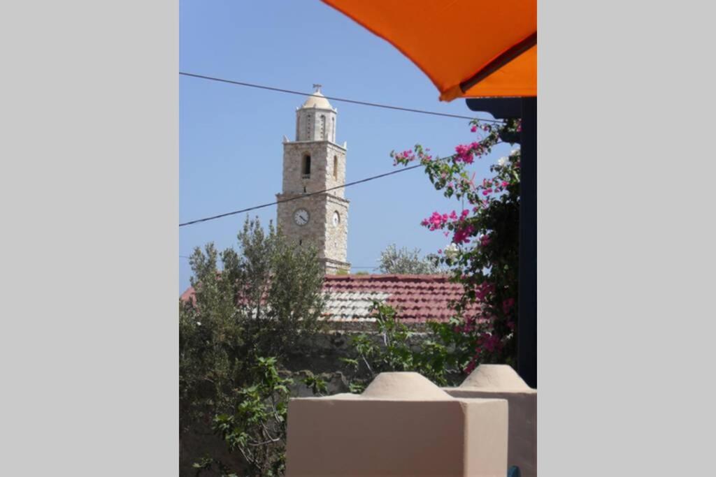 a building with a clock tower in the background at Villa Theoni in Halki