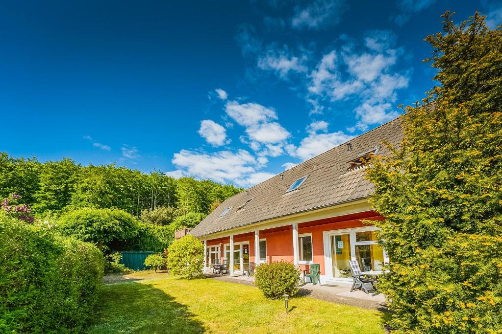 een rood huis met een dak op een erf bij Sonnensteg 5 - Ein Tag am Meer in Ostseebad Sellin