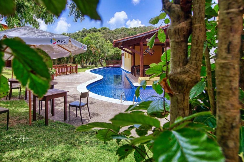 um resort com uma piscina e uma casa em APARTAMENTO 2 QUARTOS EQUIPADO NO BOSQUE DA PRAIA FLATS - PIPA NATUREZA em Pipa